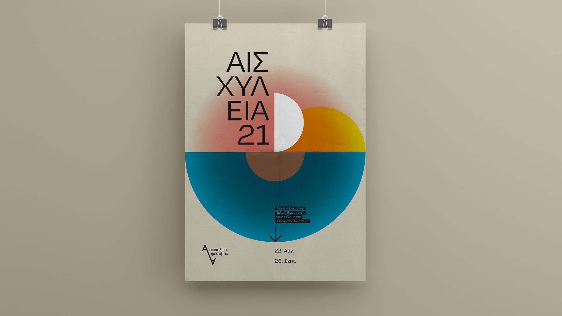A poster for the Aeschylia Festival 2021 (ΑΙΣΧΥΛΕΙΑ 21), featuring a minimalist, colorful geometric circle graphic, hanging from two binder clips against a studio wall.