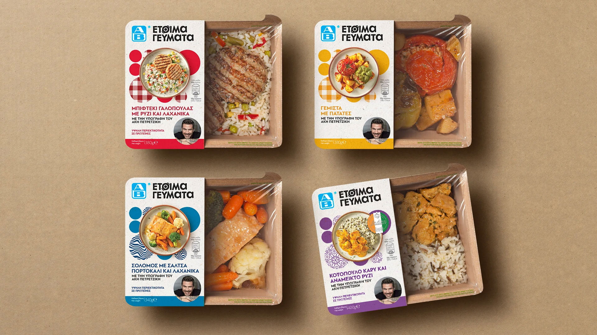 A flat lay of four different "AB Ready Meals" by Akis Petretzikis, showing the colorful packaging sleeves next to the prepared meals, including Turkey Burger, Gemista, Salmon, and Curry Chicken.