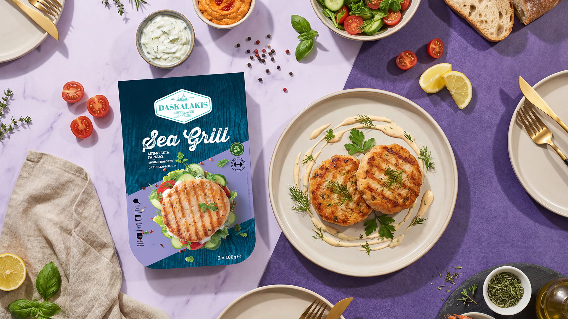 Top-down flat lay of Daskalakis Sea Grill Shrimp Burgers packaging next to a beautifully plated meal with grilled patties, fresh ingredients, and dips on a split marble and purple background, designed by 2yolk.