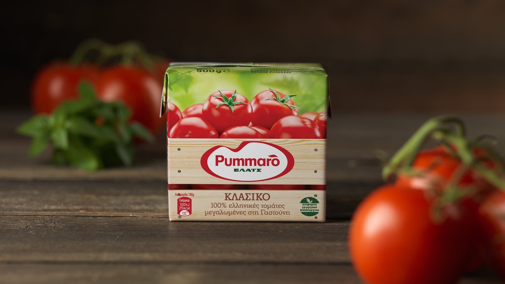 Pummaro tomato puree new packaging in Tetra Pak container, photographed on a wooden surface among fresh tomatoes